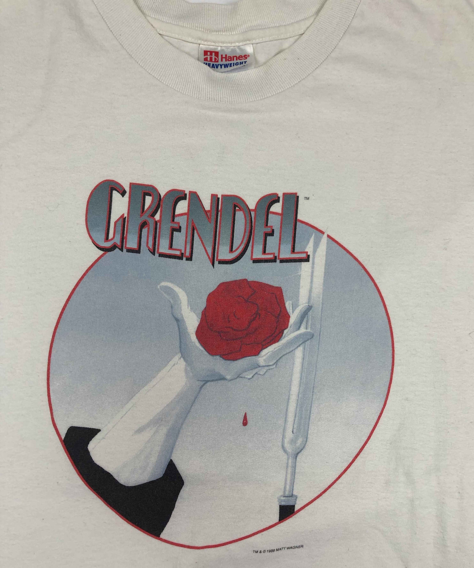 Vintage Comic T-Shirt 1999 Grendel  Grendel is a long-running series of comic books originally created by American author Matt Wagner. Grendel was the masked identity of Hunter Rose, a successful author. As Grendel, he worked as an assassin before taking control of New York City's organized crime. The tee has a good vintage condition.